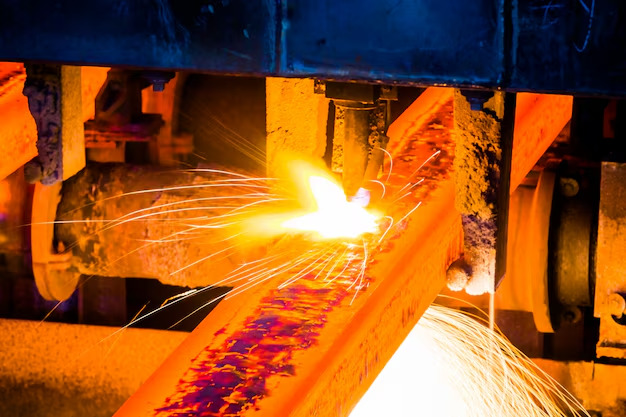 Corte láser de perfiles metálicos con chispas en planta industrial gestionada con ERP para construcciones metálicas.